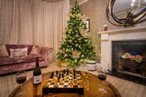 Christmas tree, wine and chess in the Quiet Lounge at Derwentwater House – cosy Lake District Christmas holiday house.